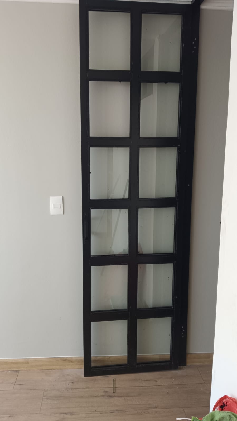 Puerta de perfilería negra y vidrio instalada por Tupyalum